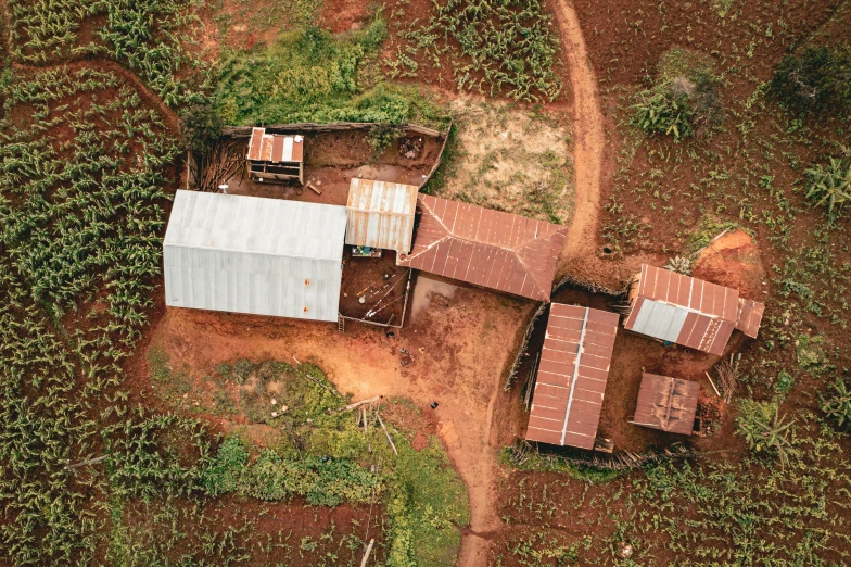 an aerial view of an old farm building and dirt road