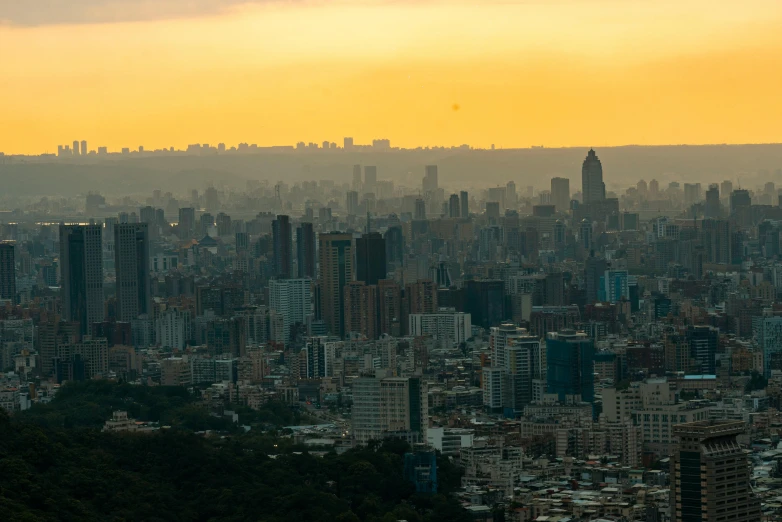 large city buildings surrounding the mountains with hazy sky