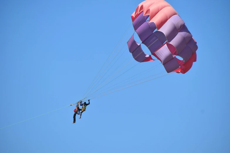 some parachute flying through the air and some people