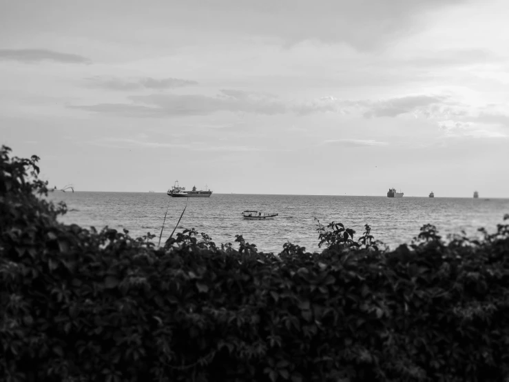 two boats sailing across the water in black and white