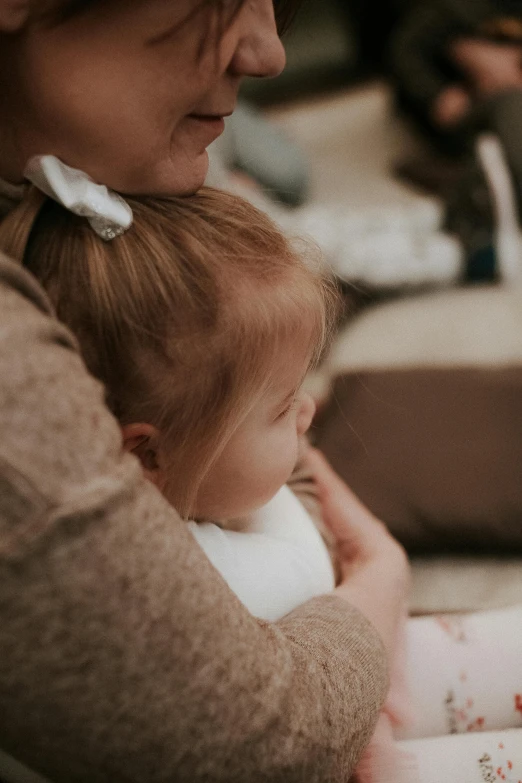 the woman holds a baby in her lap while sitting down