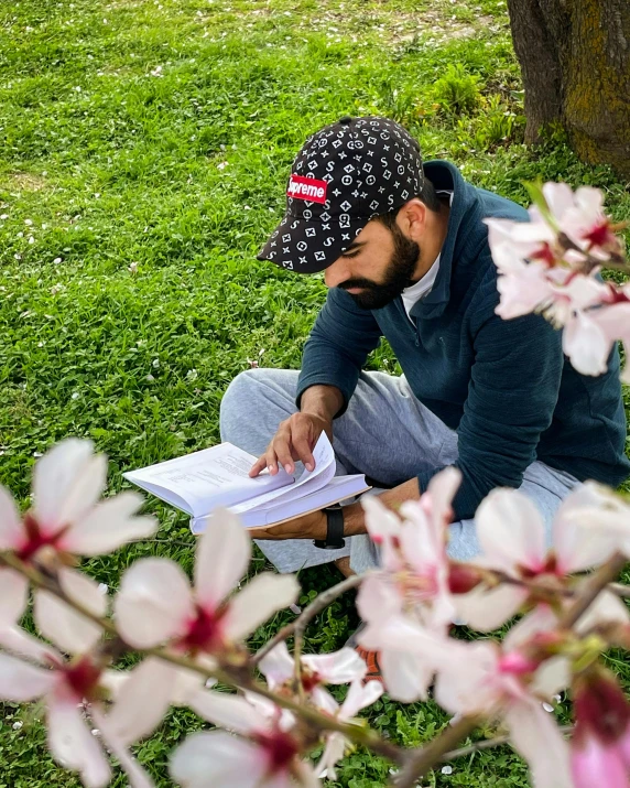 the man is sitting outside with his hand on a paper