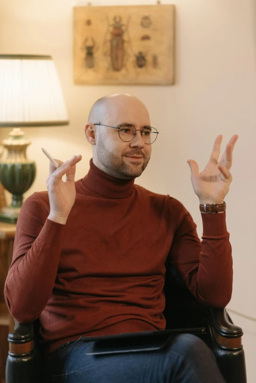 a man in a chair with one hand up