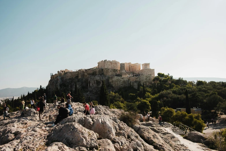 some people are standing at the edge of a rock