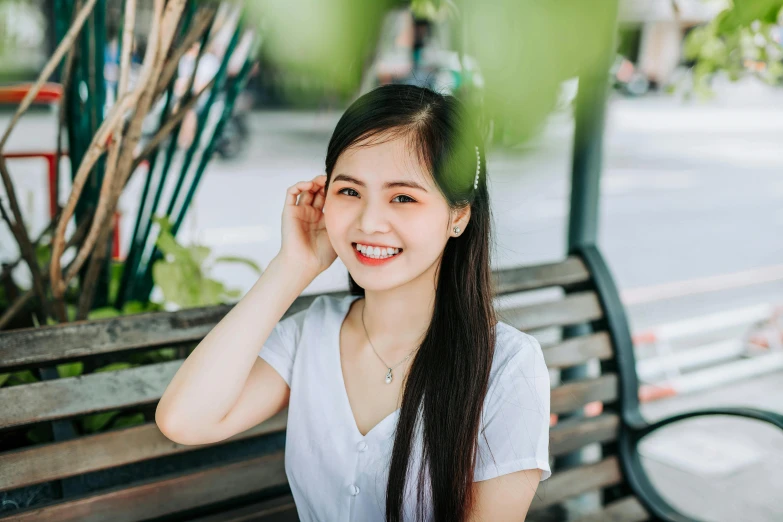 a  smiles and poses for the camera on a bench