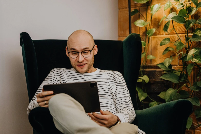 man in a chair looking at a tablet