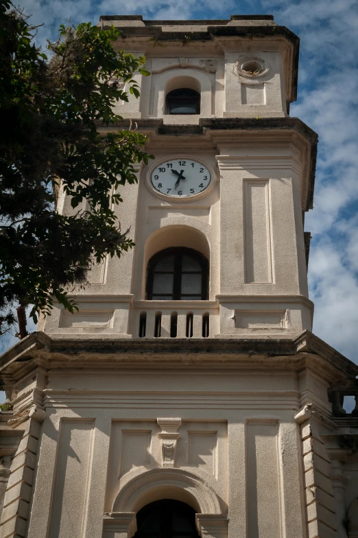 a clock tower against a blue sky with clouds