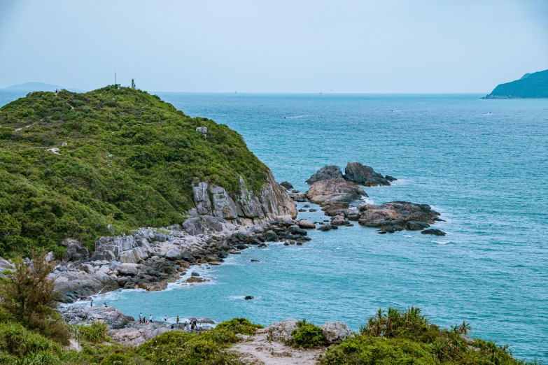 some rocks are next to the water and grass