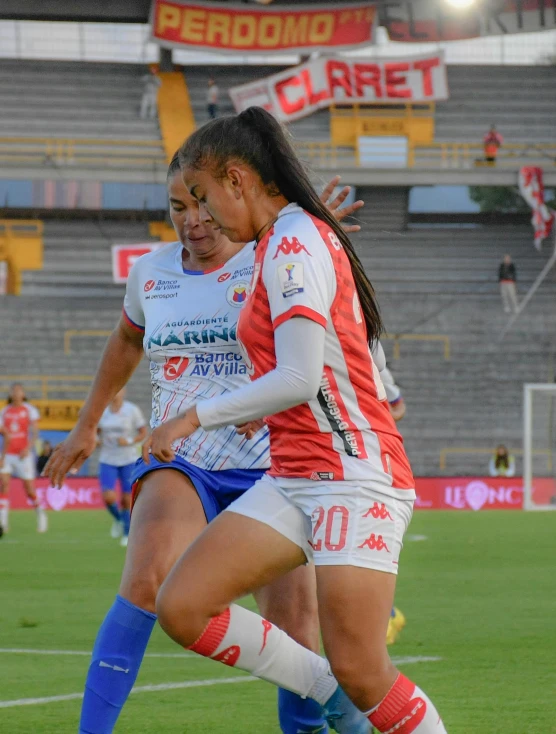 the women are playing a game on the soccer field