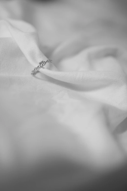 an elegant diamond ring on top of a white sheet