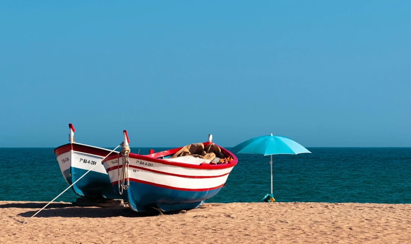 an empty boat on the shore of a beach