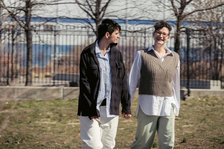 two young men are walking through the park