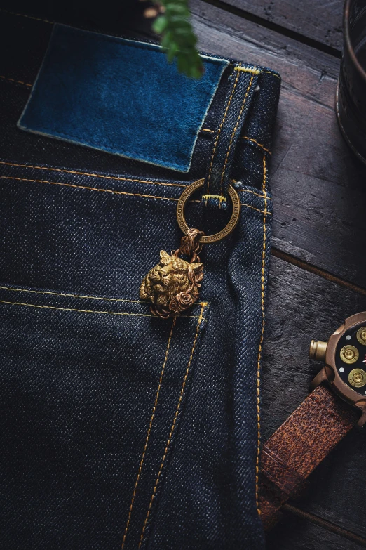 a wooden watch sitting on top of a pair of jeans