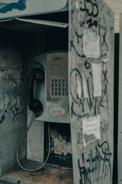 an old fashioned phone is in the graffiti covered wall