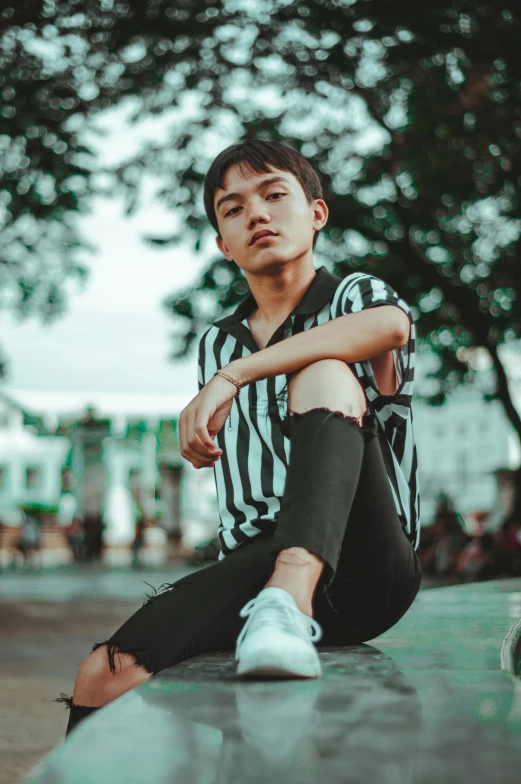 a man is sitting on a skateboard on a wet ground