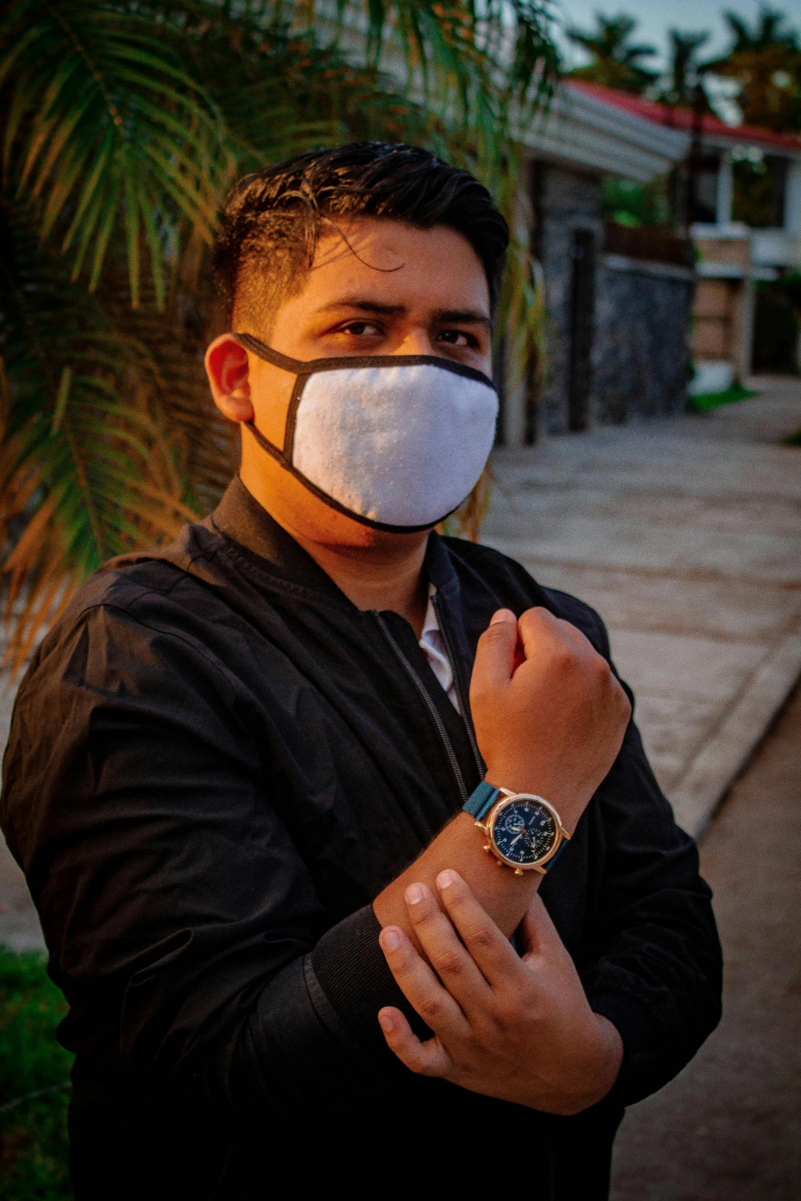 a person standing outdoors wearing a mask