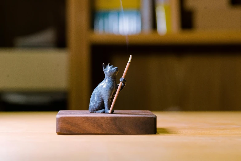 a small cat figurine on a wooden stand