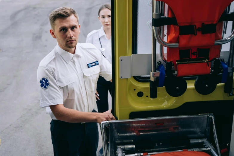 two people in uniform standing around a machine