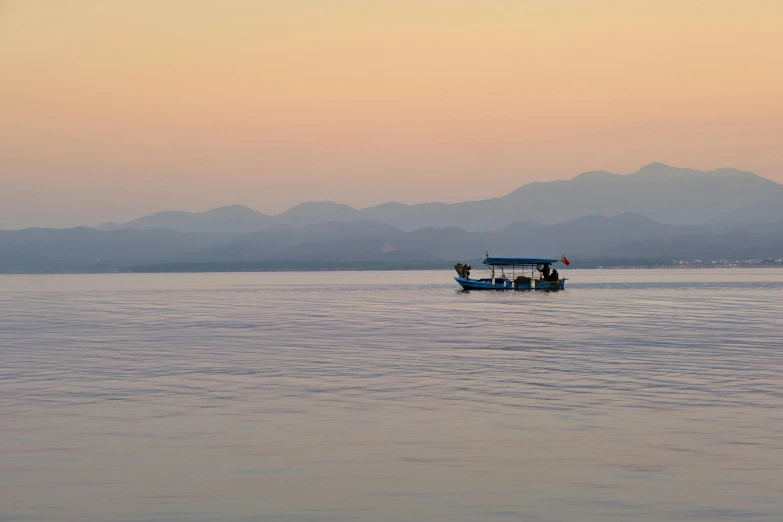 a small boat with several passengers on calm water