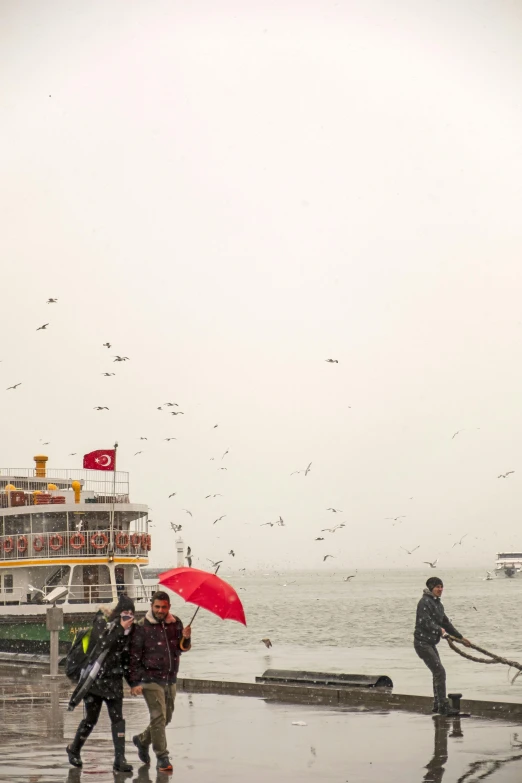 a boat in the ocean and people with umbrellas