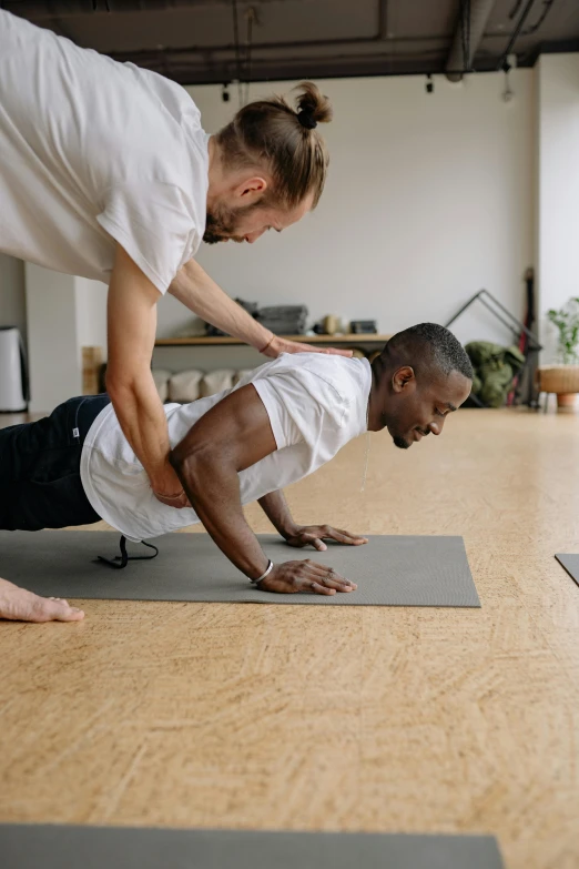 a man and woman on mats are doing yoga