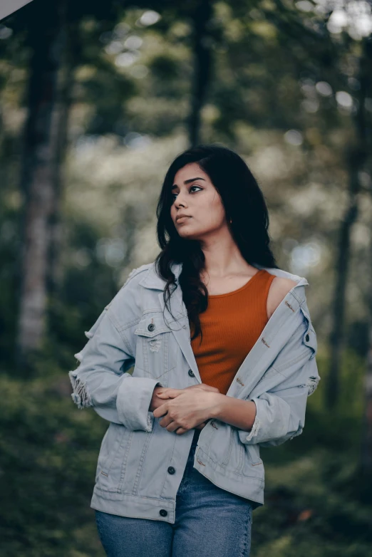 a woman is wearing blue jeans and a denim jacket