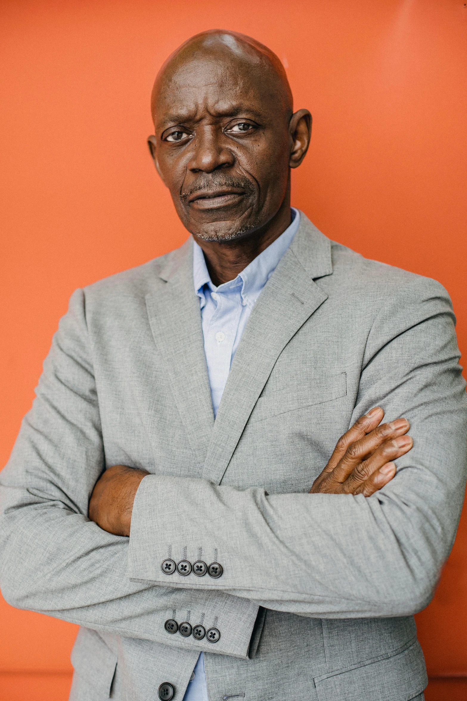 a man standing with his arms crossed and looking off into the distance