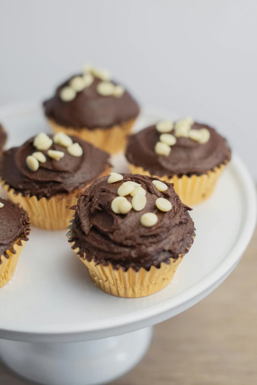 several chocolate cupcakes with nuts on top of them