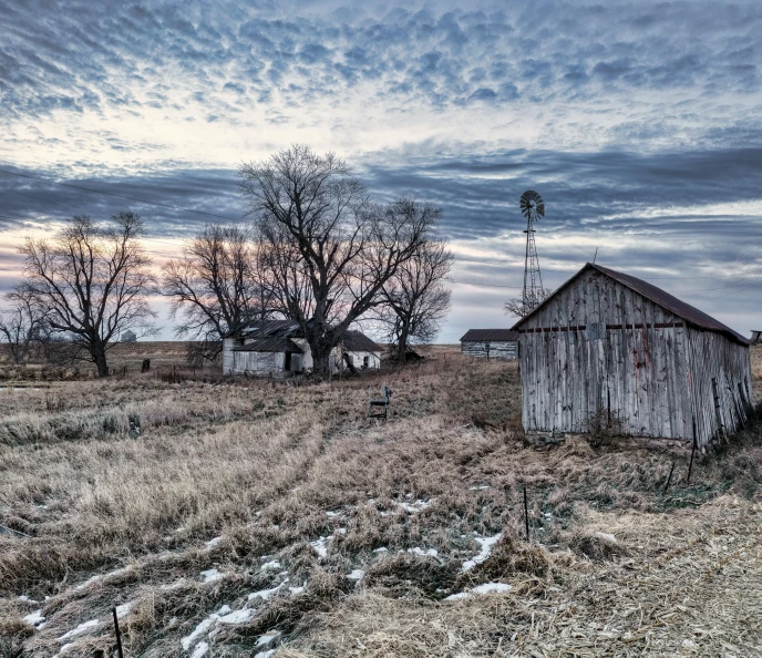 a large wooden barn in a barren landscape