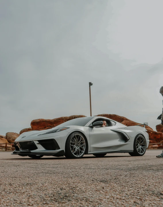 a person standing in front of a sports car