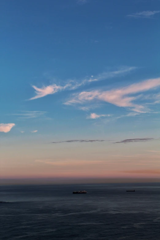 some very pretty clouds in the sky above the water