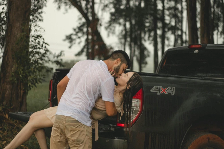 man giving woman kisses her head and kissing her cheek