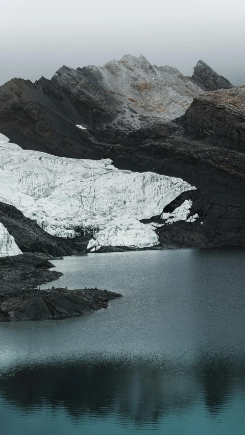 large mountains and ice covered lakes on a gray and overcast day