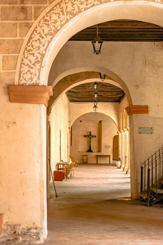 a room with a long stone archway and some benches