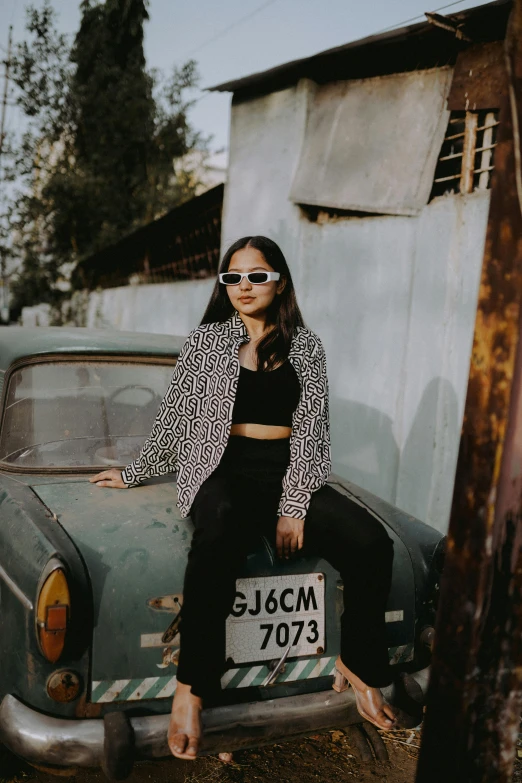 a woman sitting on the back of an old car