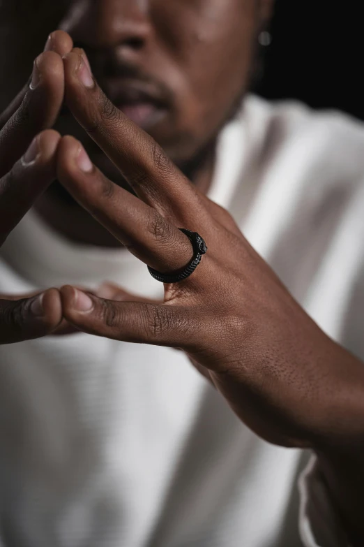 a man holding his hand out and wearing a black ring