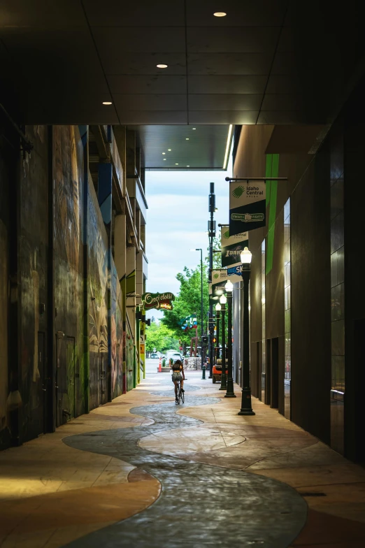 the motorcycle rider rides through an alley of a building