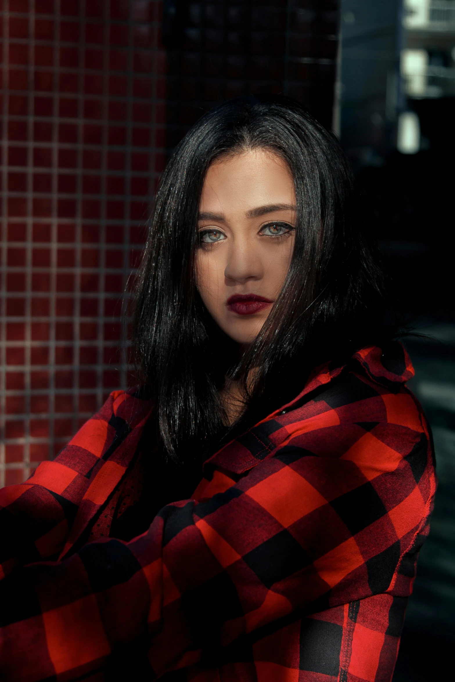 a young woman in red and black shirt poses for a po