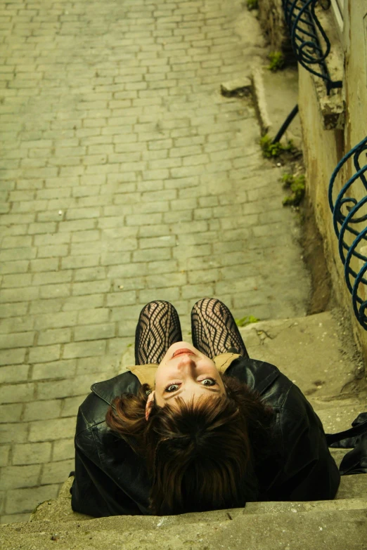 a woman laying on the ground, her head down, with a black dress