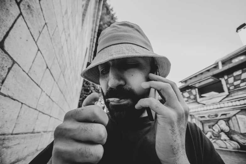 a man holding up a cigarette and looking away from the camera