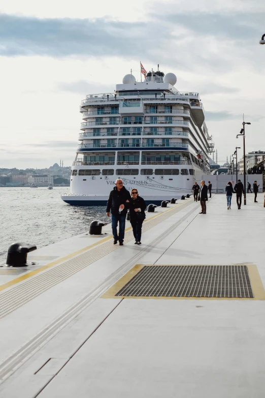 cruise ship docked at dock near dock with pedestrians walking near