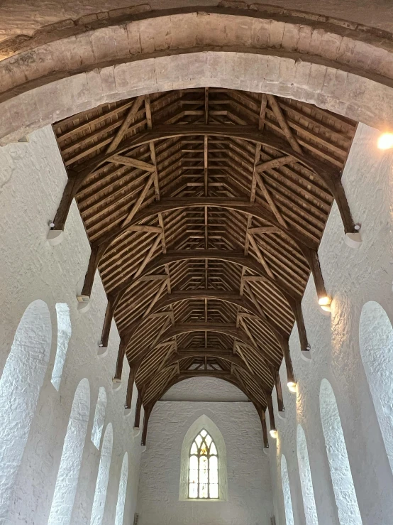 a ceiling in a large building with wooden beams