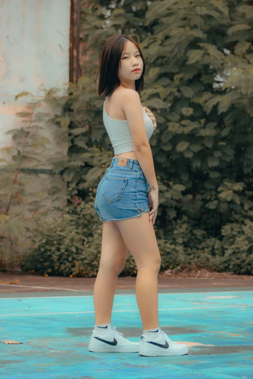 young woman in tight jean shorts with high heels posing