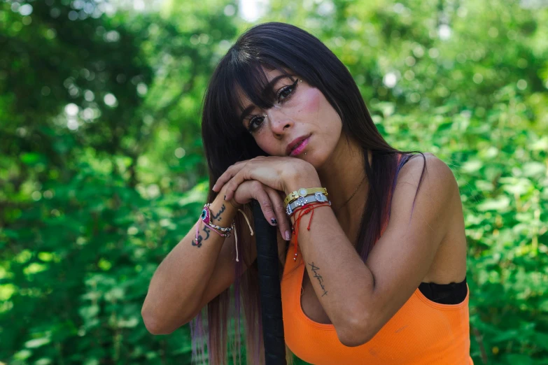 a beautiful young lady wearing jewelry and holding her hand on her hip