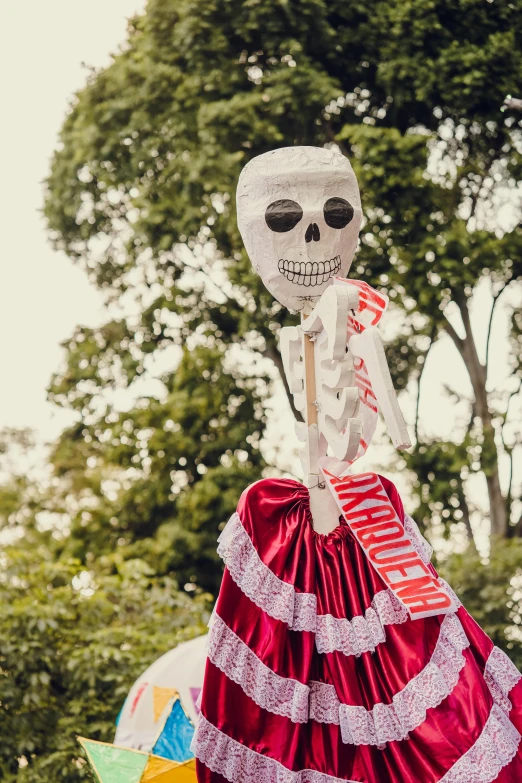 a skeleton in a skirt is being walked by some people