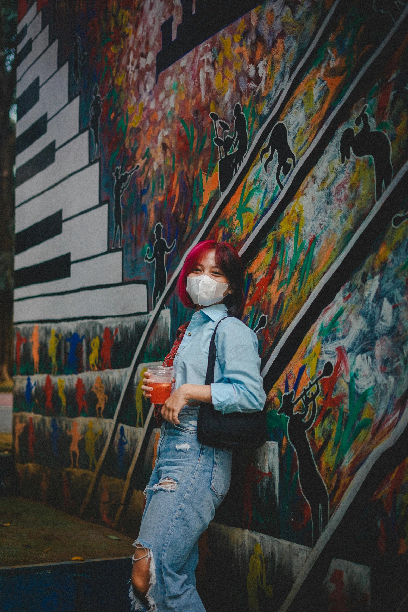 a girl standing in front of an artistic wall