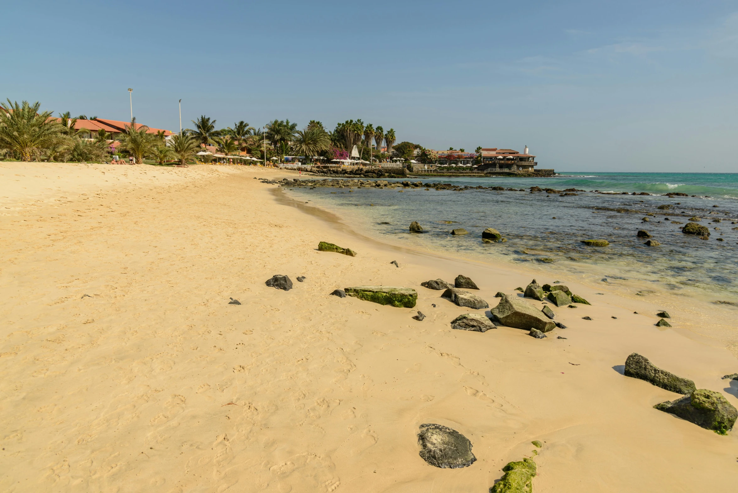 a sandy beach with lots of rocks on it