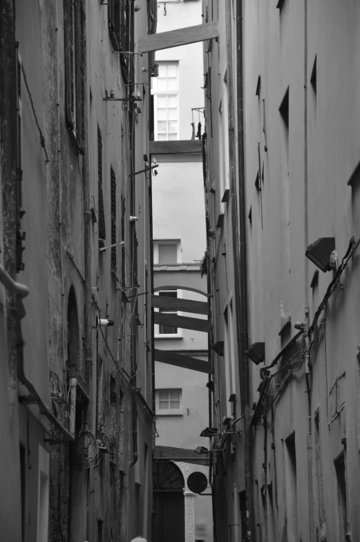 a woman walking through an alleyway in an old town