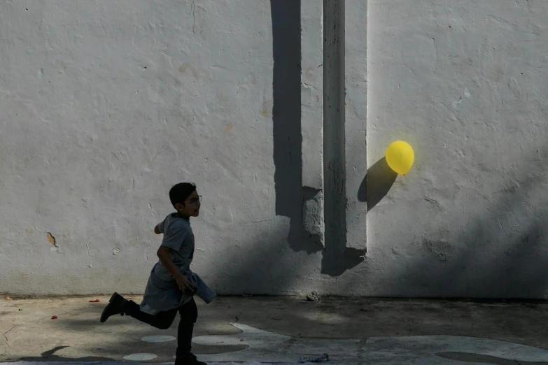 a child is running past an object on the sidewalk