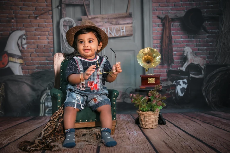 a baby boy sitting in a chair holding an object